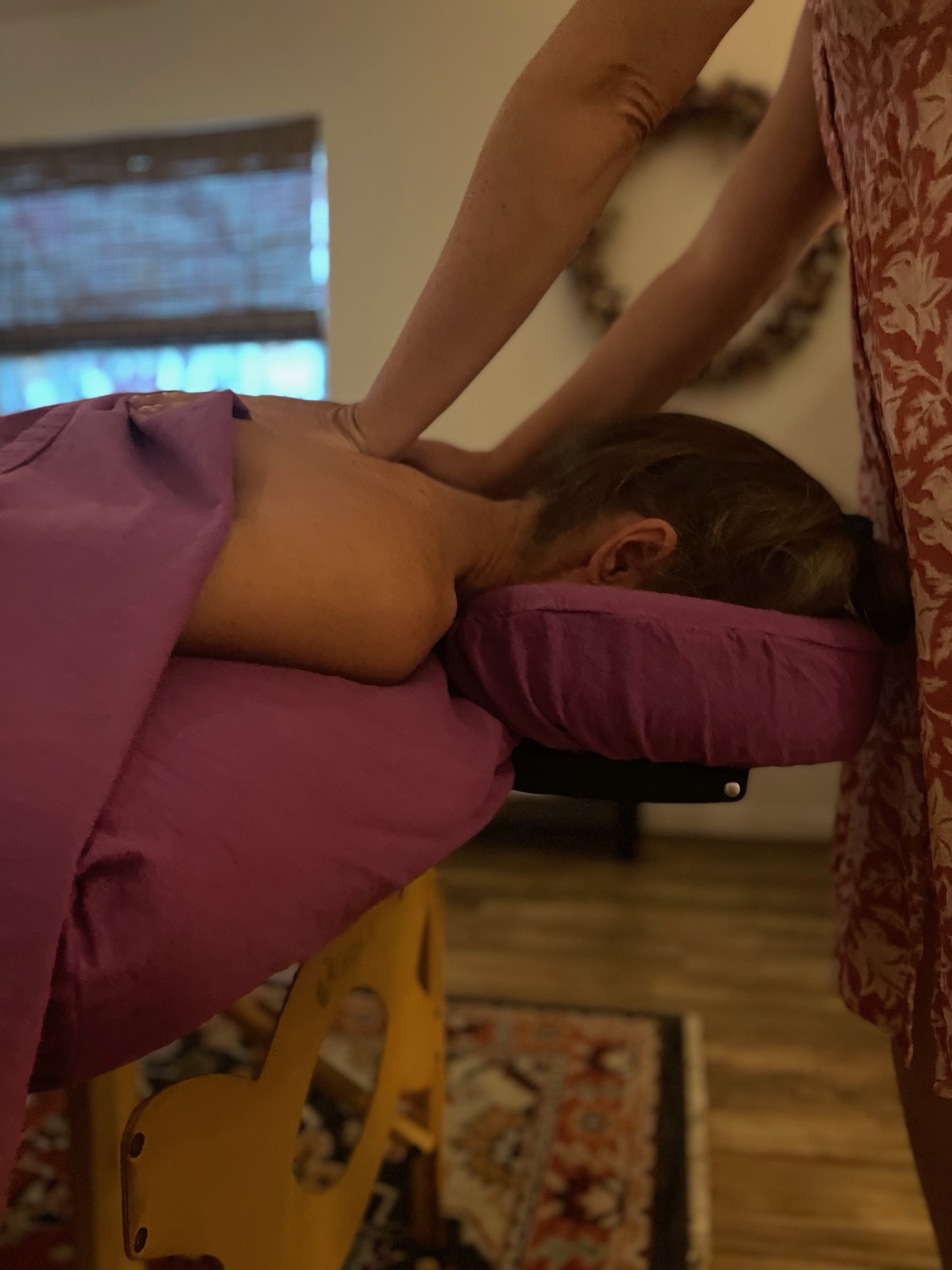 Brieann's hands working on a client's shoulders