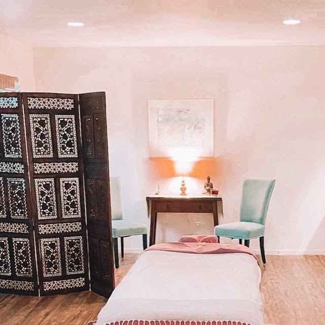 Brieann's treatment room with a carved screen and aqua chairs